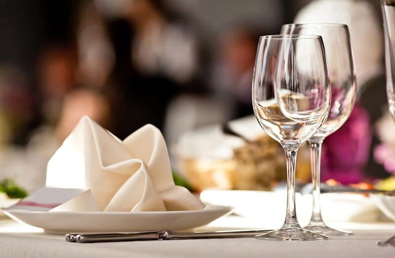 table with plates, wine glasses, and napkins